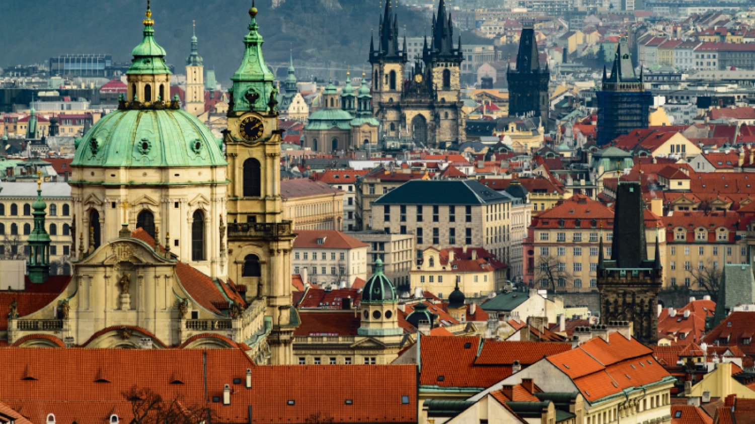 Panorama Starego Miasta w czeskiej Pradze, widok na kościoły oraz spadziste czerwone dachy.
