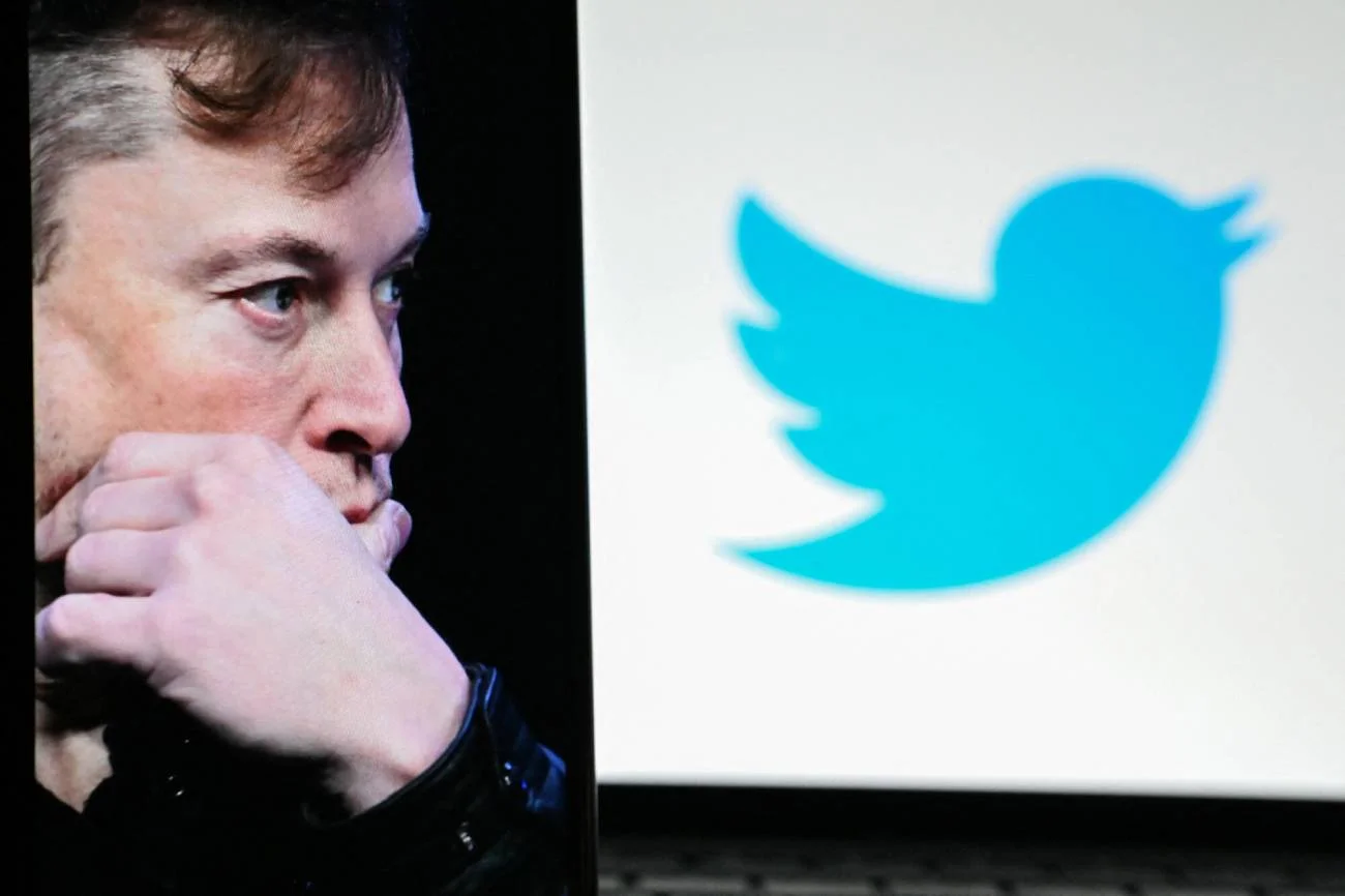 Elon Musk przed logiem Twittera.