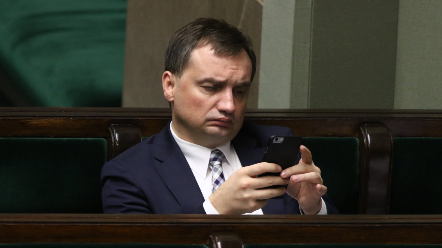 Zbigniew Ziobro przegląda telefon