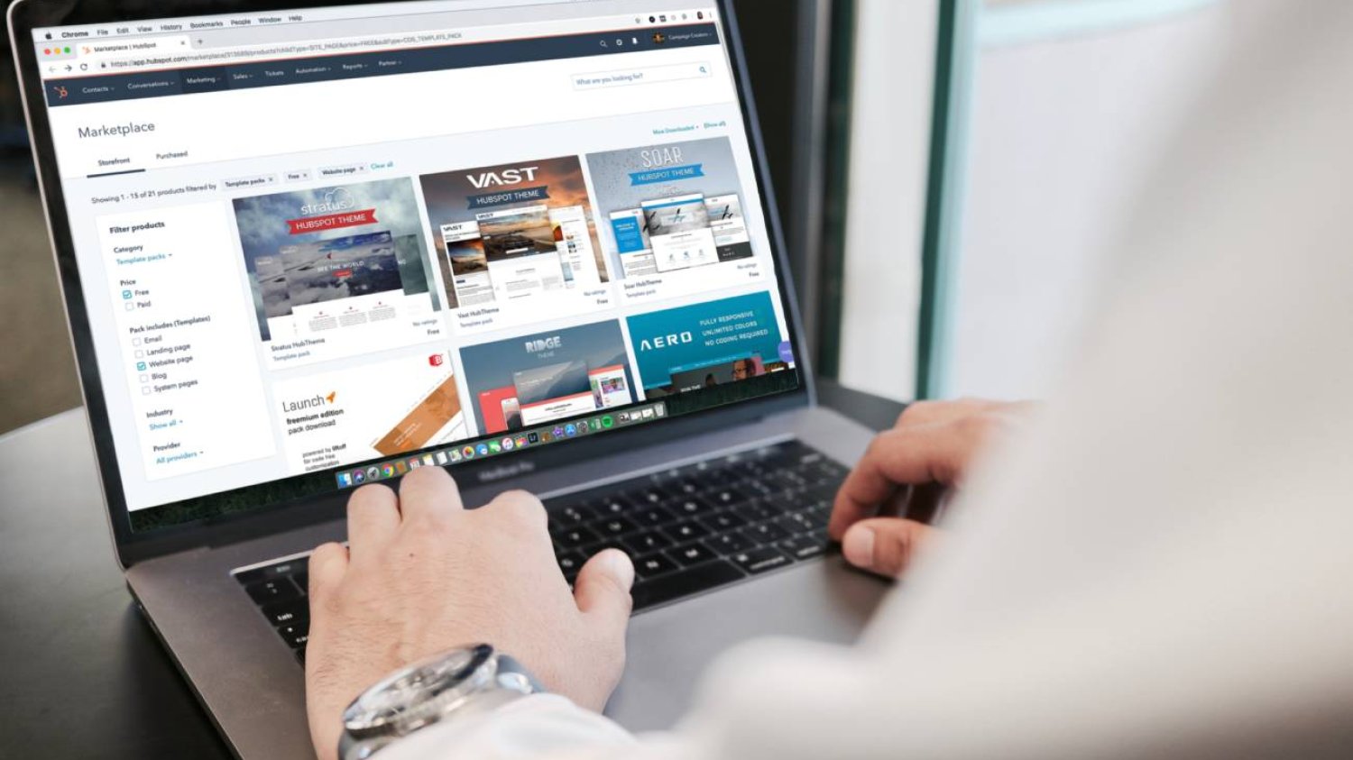 Mężczyzna przy laptopie, na którego ekranie otwarty jest sklep internetowy