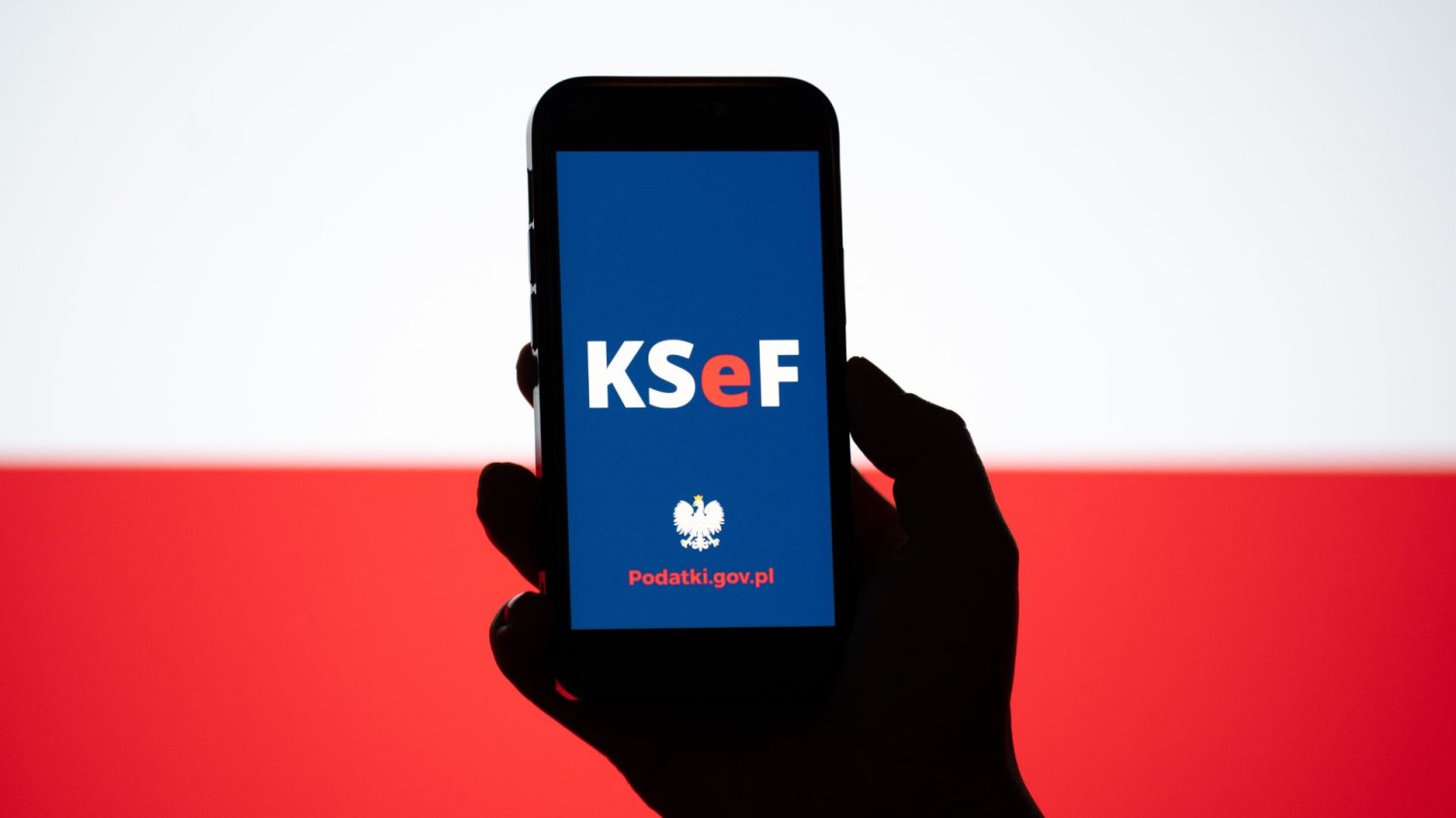 KSeF w telefonie na tle mapy Polski.
