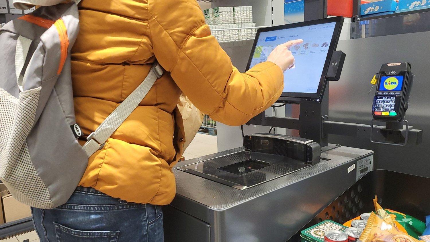 Nowe kasy samoobsługowe w Lidlu. Koniec z "zakupowym Tetrisem". Kobieta kasuje produkty przy kasie samoobsługowej Lidl.