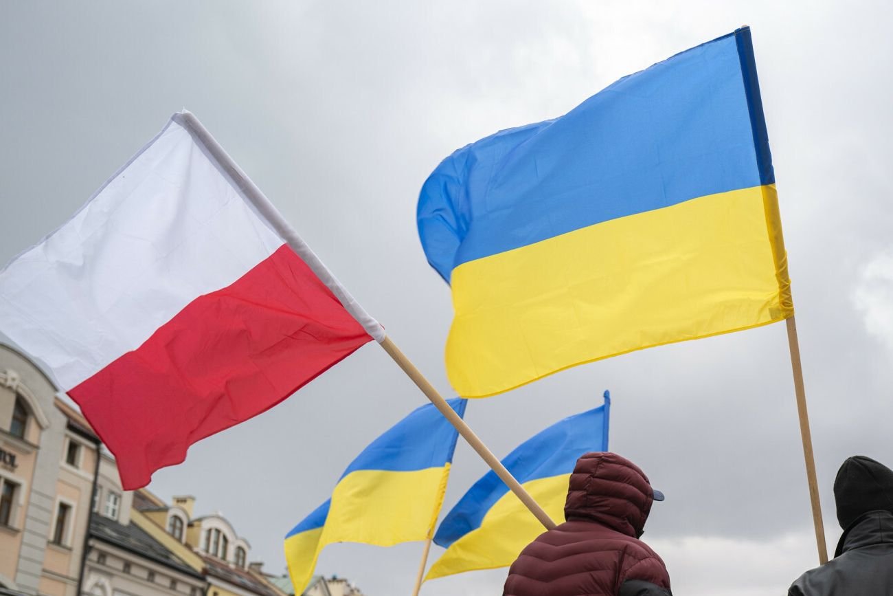 mężczyźni z flagami Polski i Ukrainy