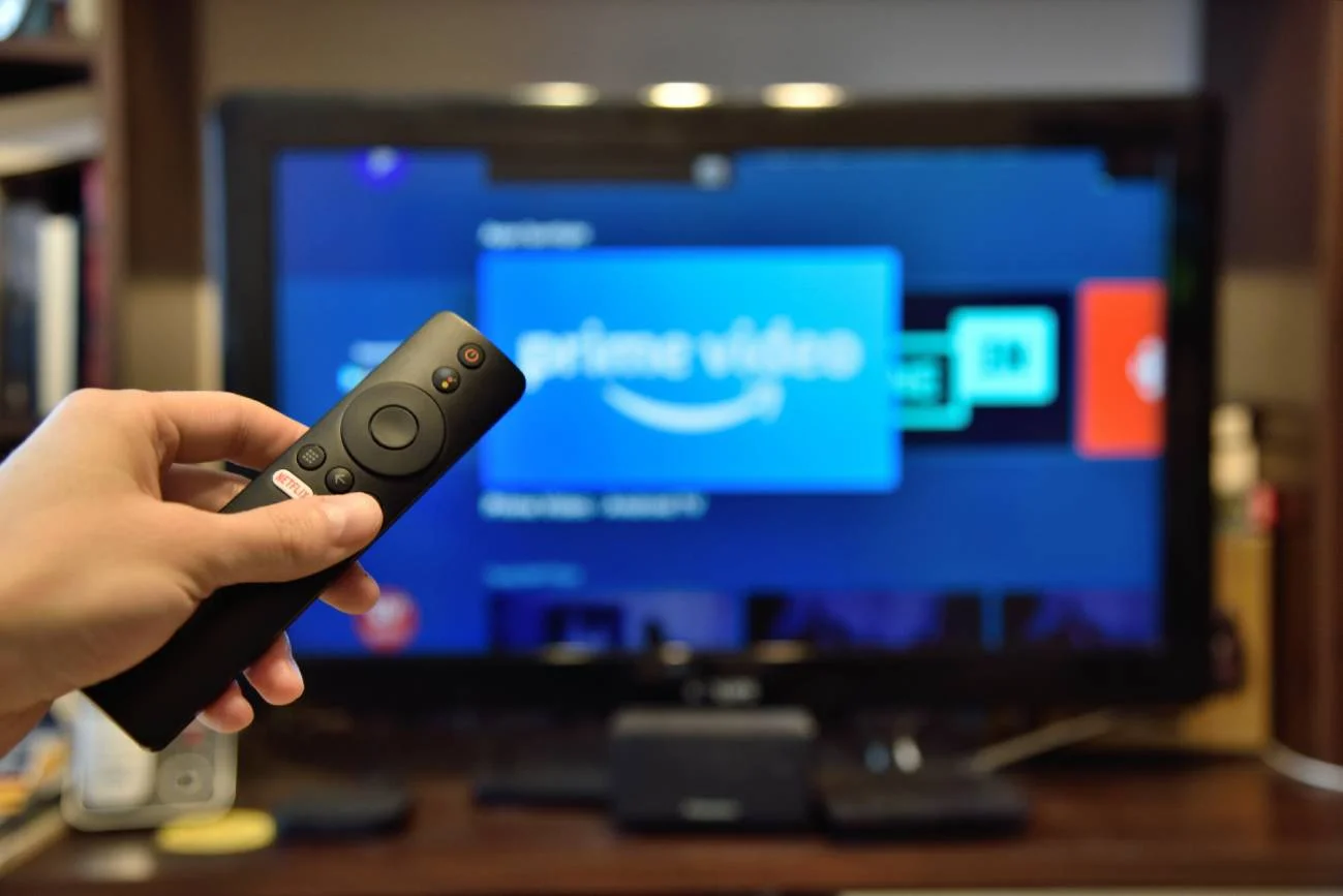 pilot na pierwszym planie, a w tle telewizor z logo Prime Video.