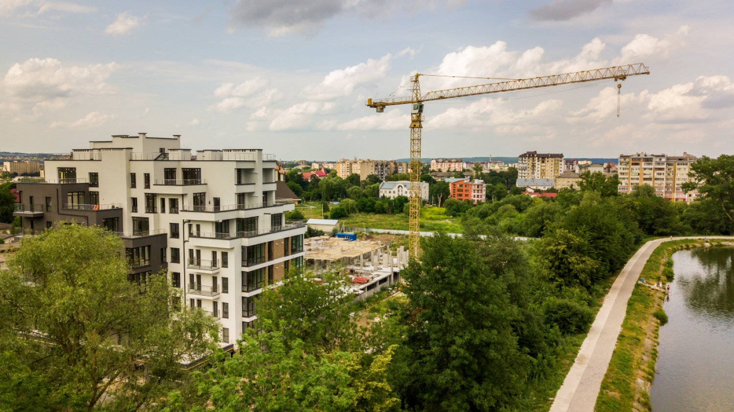 widok z lotu ptaka dźwig wieżowy i betonowa rama wysokiego budynku mieszkalnego w budowie w mieście