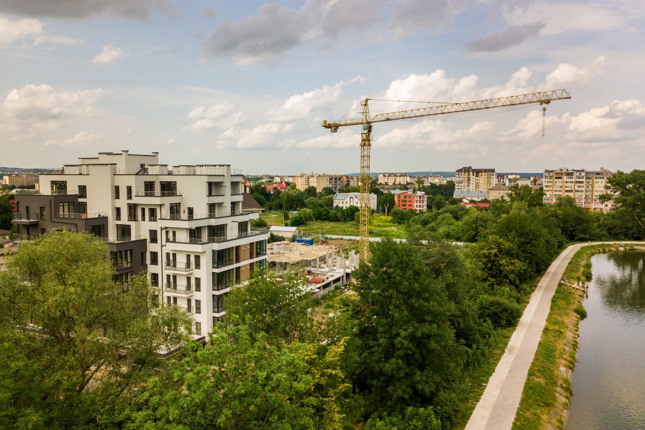 widok z lotu ptaka dźwig wieżowy i betonowa rama wysokiego budynku mieszkalnego w budowie w mieście