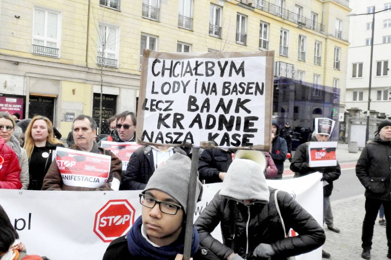 Manifestacja – transparent z napisem "Chciałbym lody i na basen, lecz bank kradnie nasza kasę."
