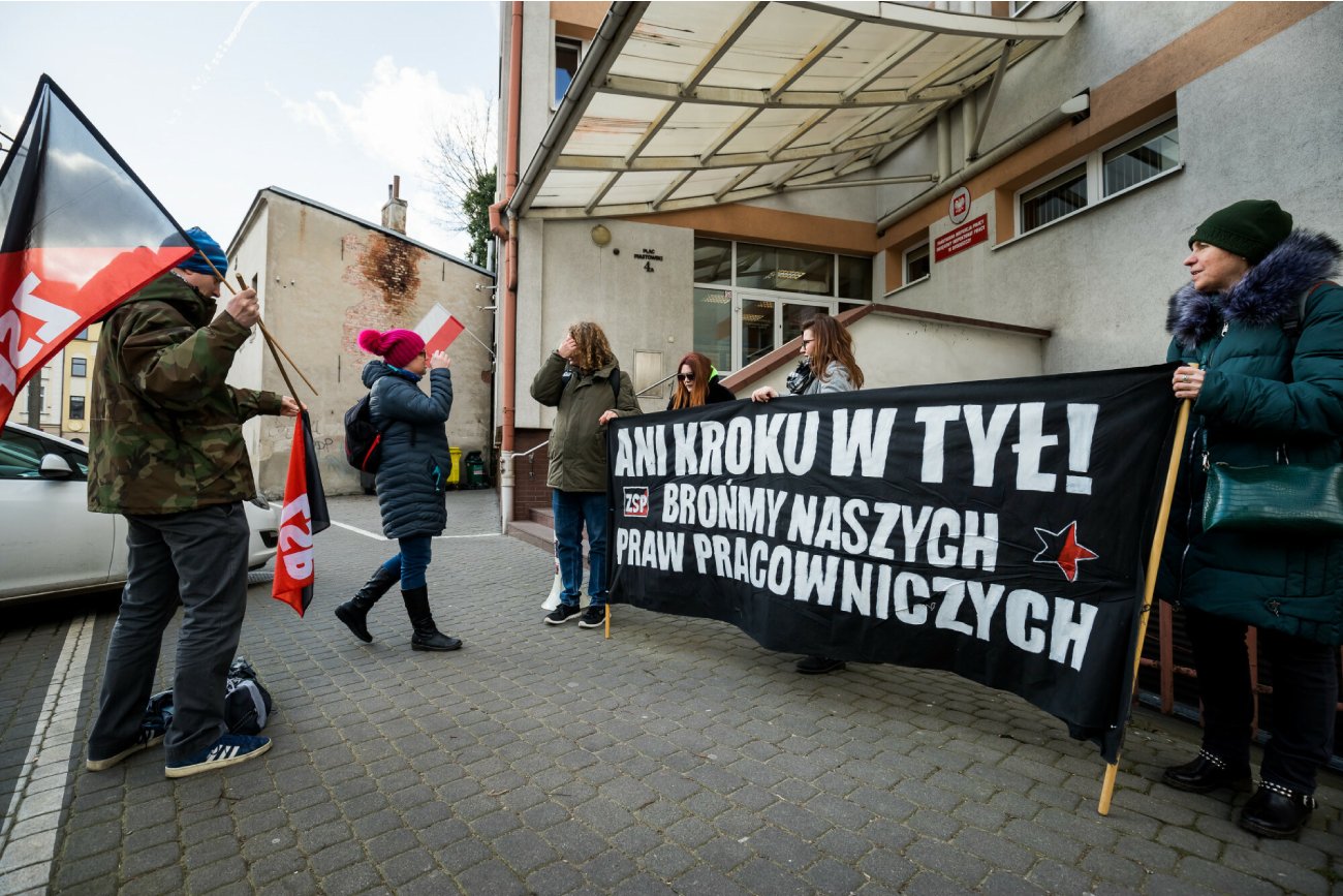 ludzie protestujący z transparentami o lepsze warunki pracy