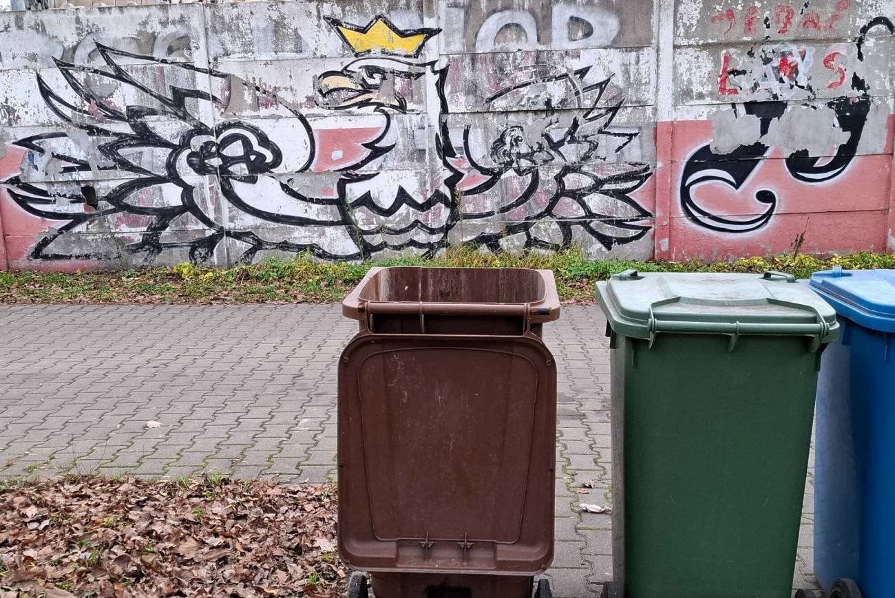 Kosze na odpady na tle muralu.
