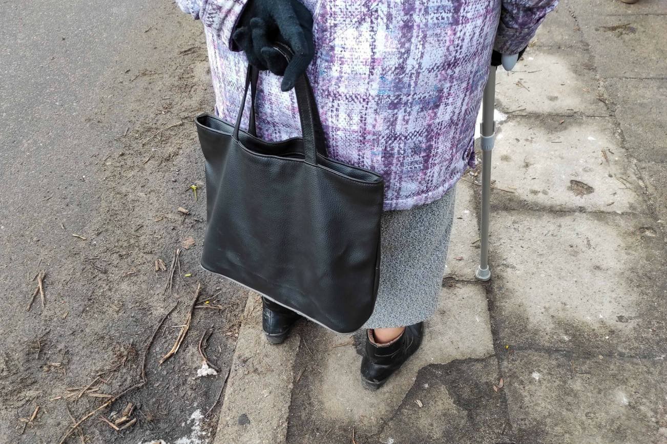 Emerytka z torbą i o kuli.