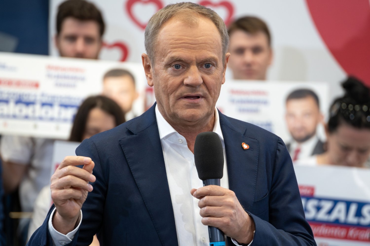 Donald Tusk przemawia z mikrofonem w ręku.