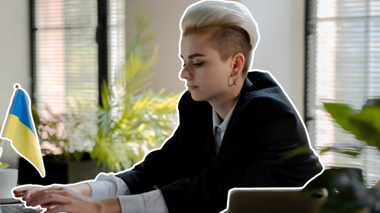 Kobieta, business woman, pracuje. Na biurku przed nią jest flaga Ukrainy.