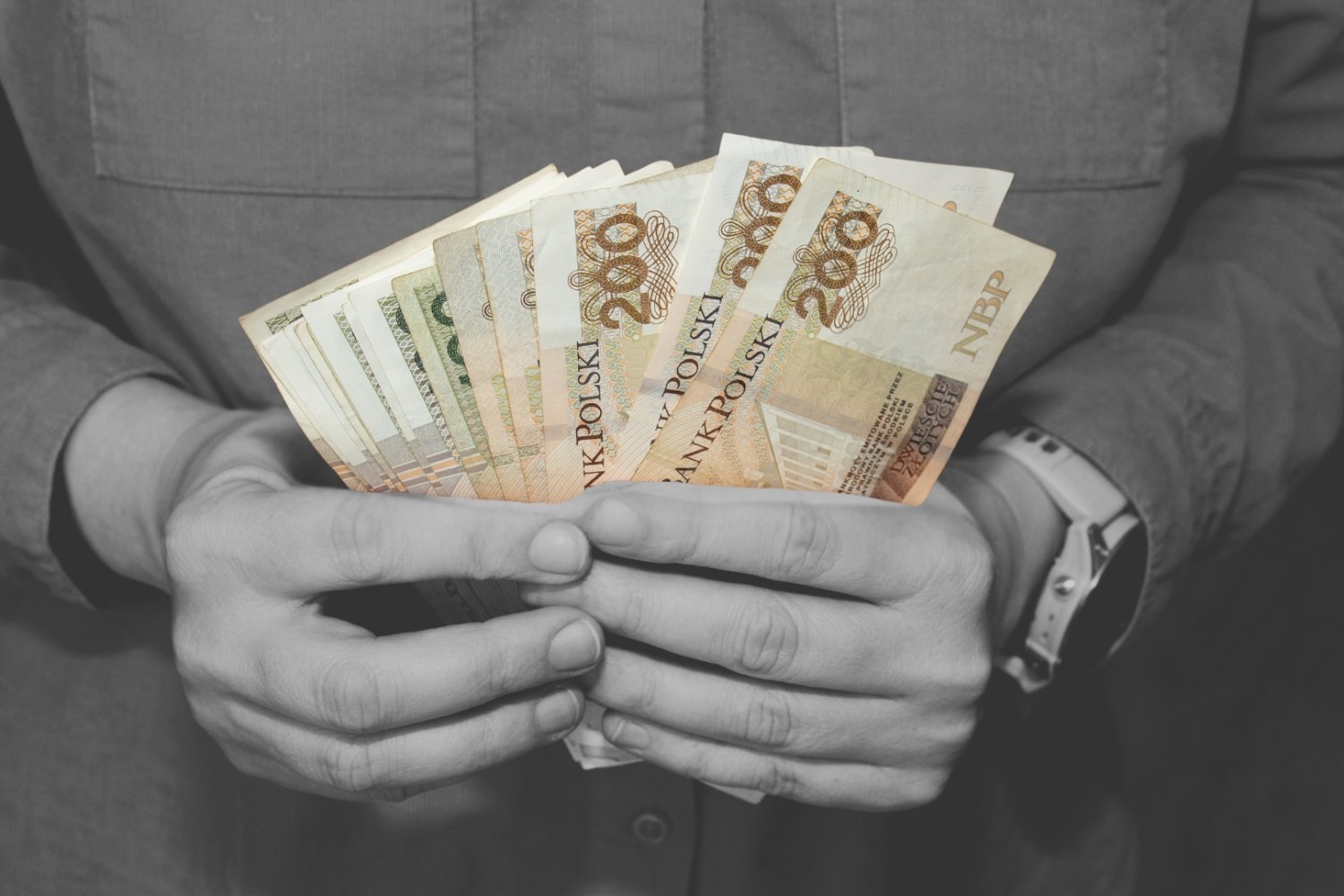 mężczyzna trzymający gotówkę