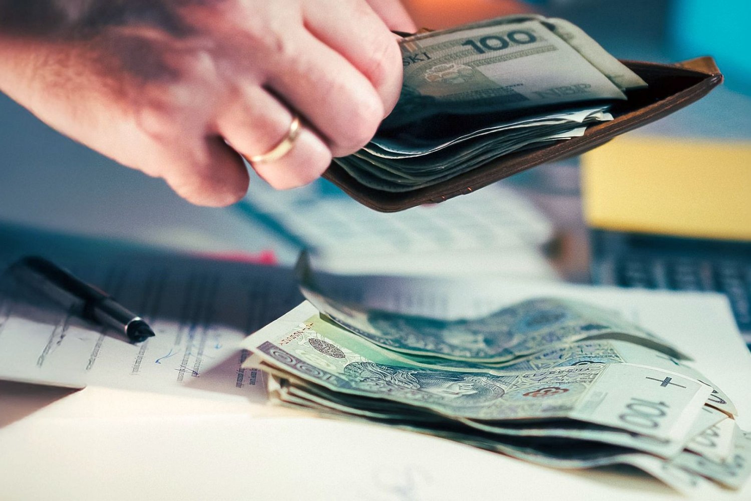 mężczyzna wyciągający pieniądze z portfela