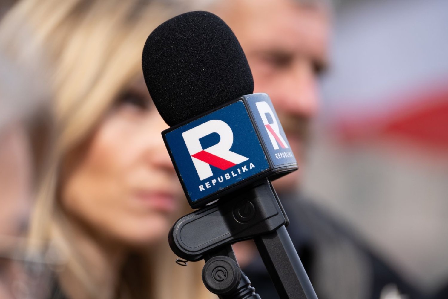 Mikrofon z odznaczeniem TV Republika, w tle ludzie.