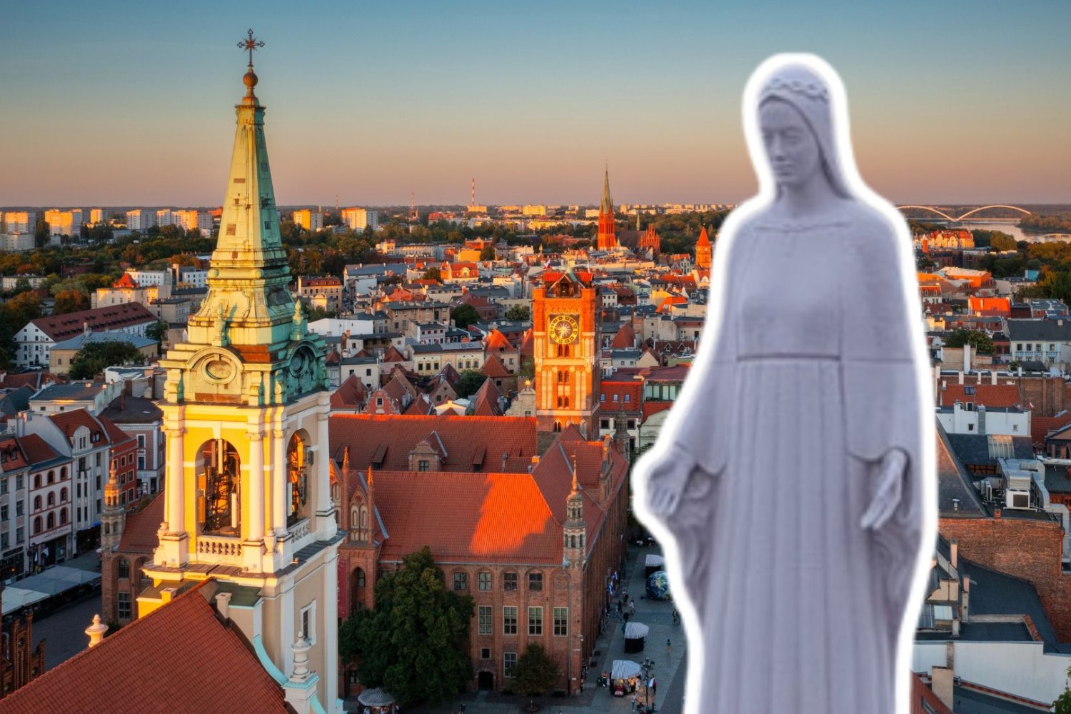 Makieta pomnika Matki Boskiej na tle panoramy Torunia.