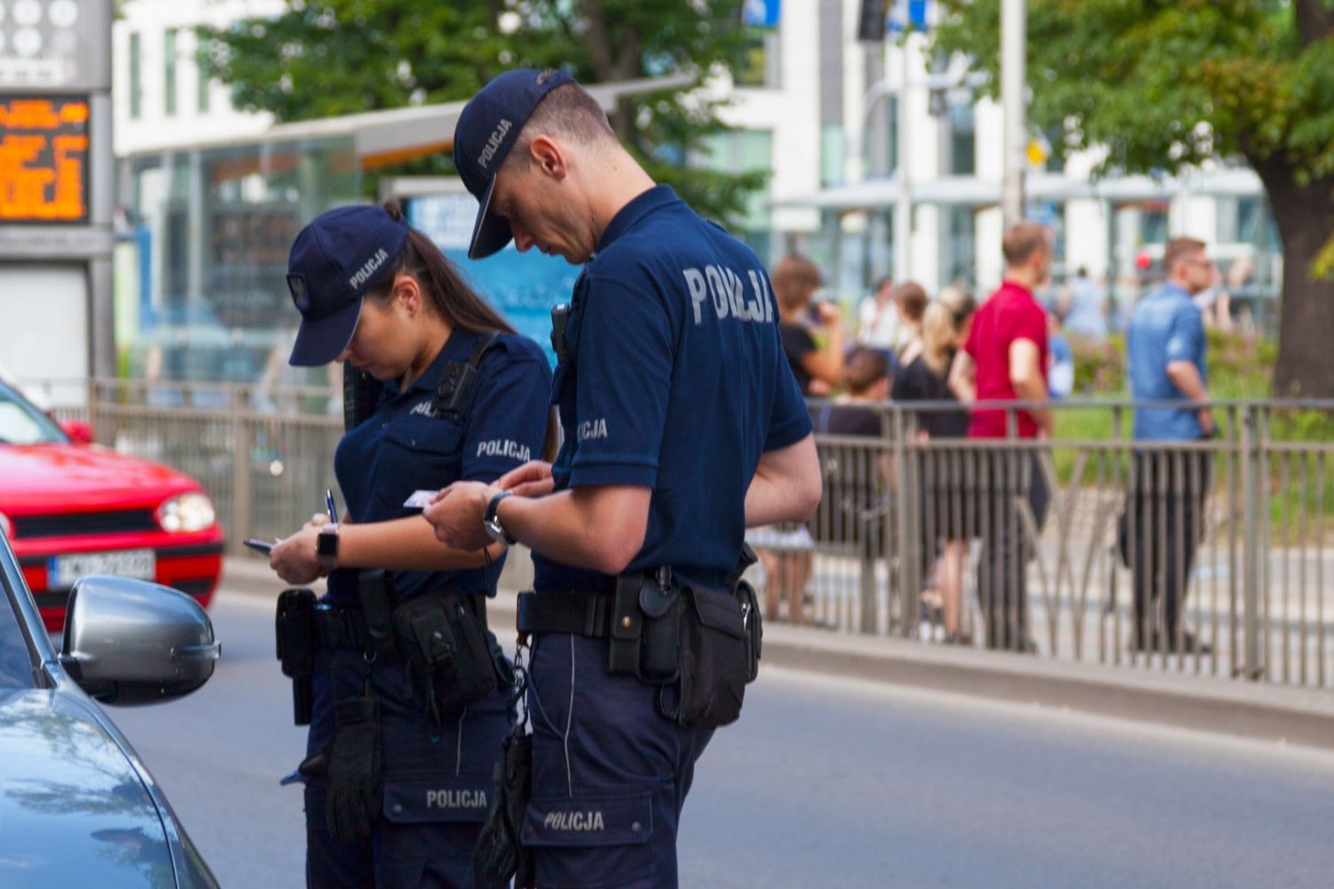 Jak sprawdzić liczbę punktów karnych? Zrobisz to online w kilka minut Dwoje funkcjonariuszy policji z notesami przy prywatnym samochodzie.