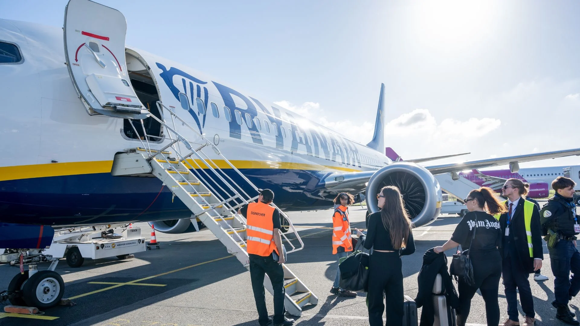 Ryanair zapowiada nawet 200 nowych miejsc pracy w Polsce w 2027 roku. Pracownicy i pasażerowie Ryanair przy samolocie.
