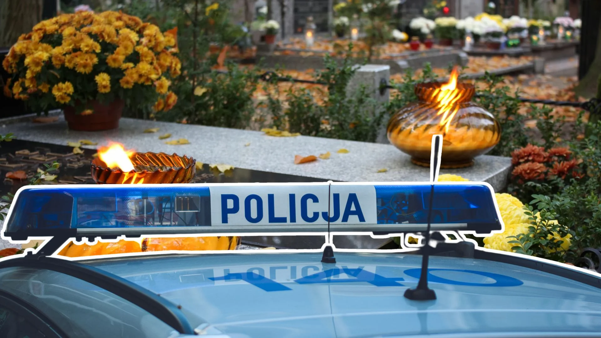 Radiowóz na tle cmentarza.