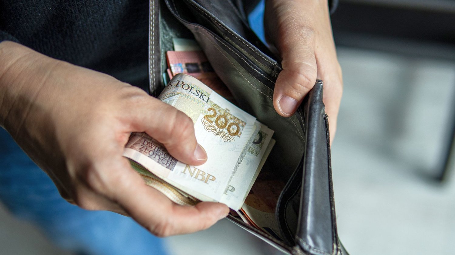 Polacy zamienili PPK w bankomat. Z systemu wyparowało 2,7 miliarda złotych ręka chowająca pieniądze do portfela