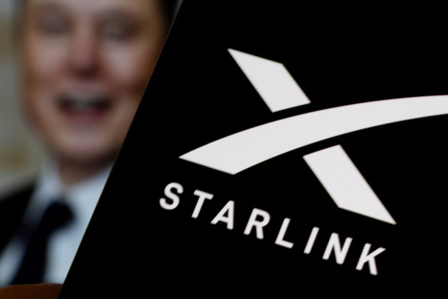 Starlink w aplikacji, w tle Elon Musk.