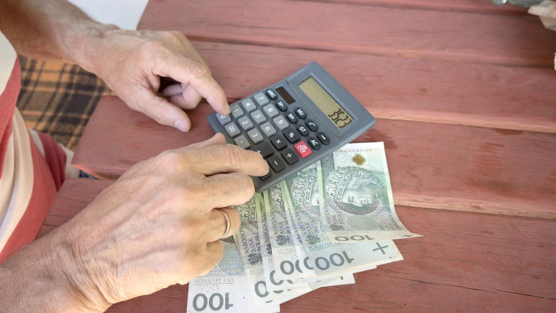 Te osoby mogą przejść wcześniej na emeryturę. ZUS stawia konkretne warunki Starszy człowiek, kalkulator i polskie banknoty. Wcześniejsza emerytura dla roczników 1949–1968. Kto nadal ma prawo?