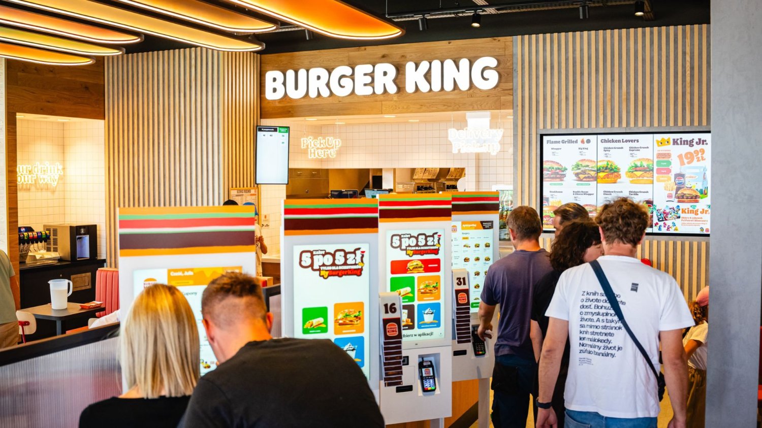 Burger King rozdaje burgery za 5 zł. Jest jeden warunek. ludzie w lokalu Burger King.