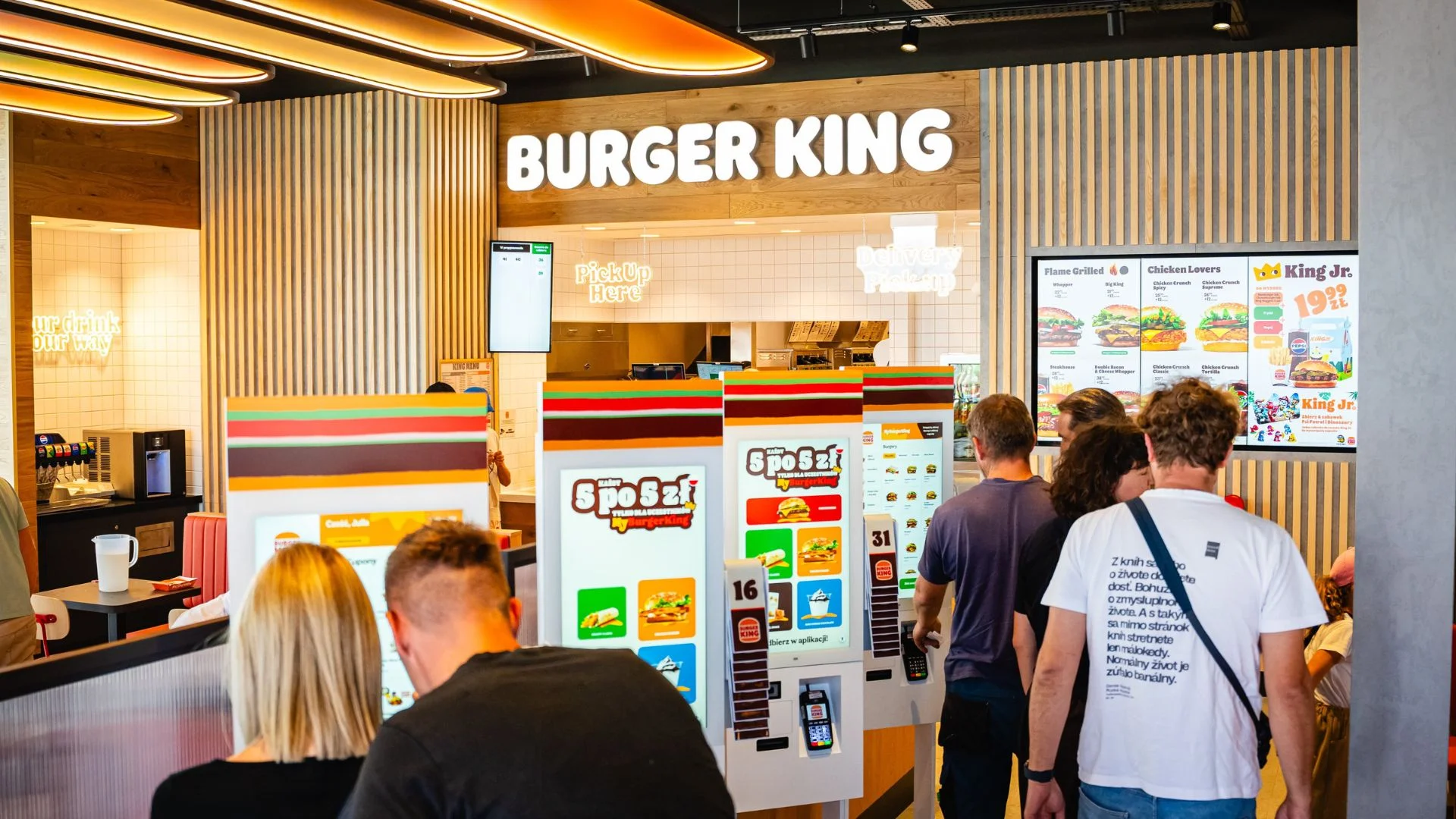 Burger King rozdaje burgery za 5 zł. Jest jeden warunek. ludzie w lokalu Burger King.