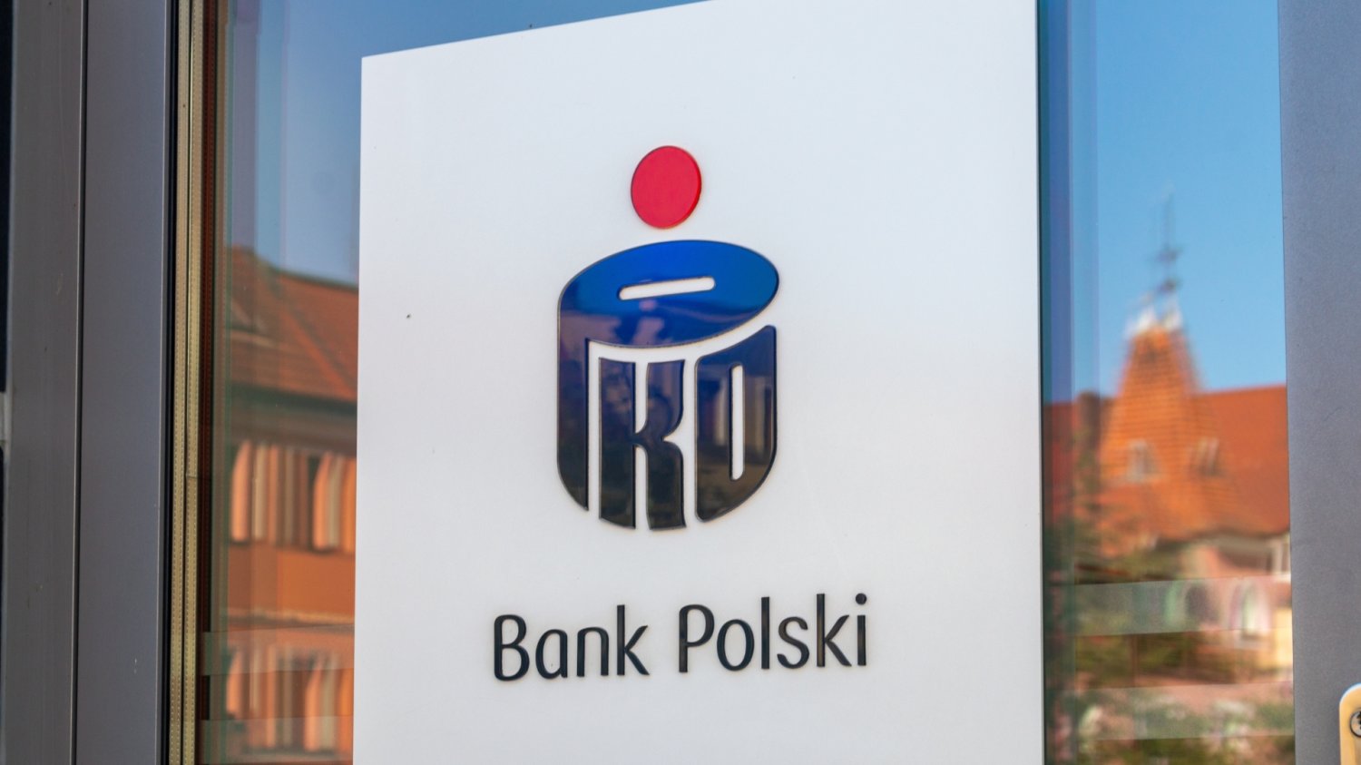 KNF nałożyła 47,5 mln zł kary na PKO BP. Wiemy, czego dotyczą zarzuty Drzwi do budynku PKO BP. Logo banku na drzwiach.