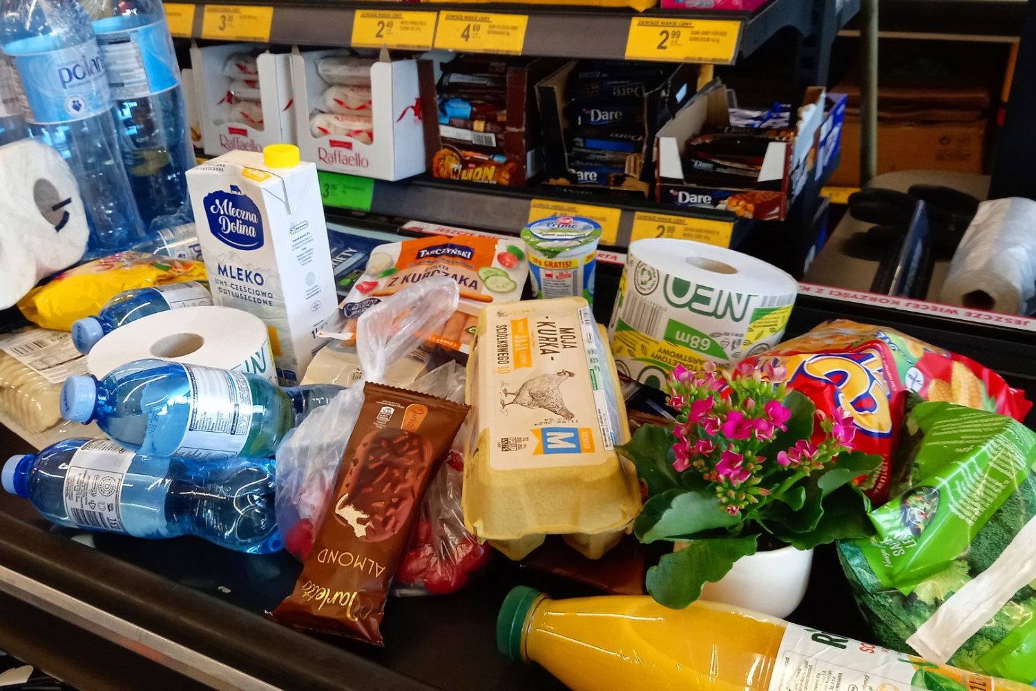 Produkty spożywcze na taśmie przy kasie w sklepie.