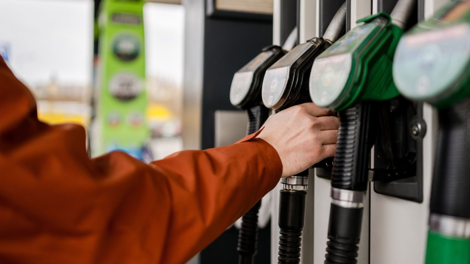 Idą kolejne podwyżki na stacjach. Benzyna po 8 zł, a diesel przebije 9?/ Człowiek sięga po pompę paliwa przy dystrybutorze na stacji.