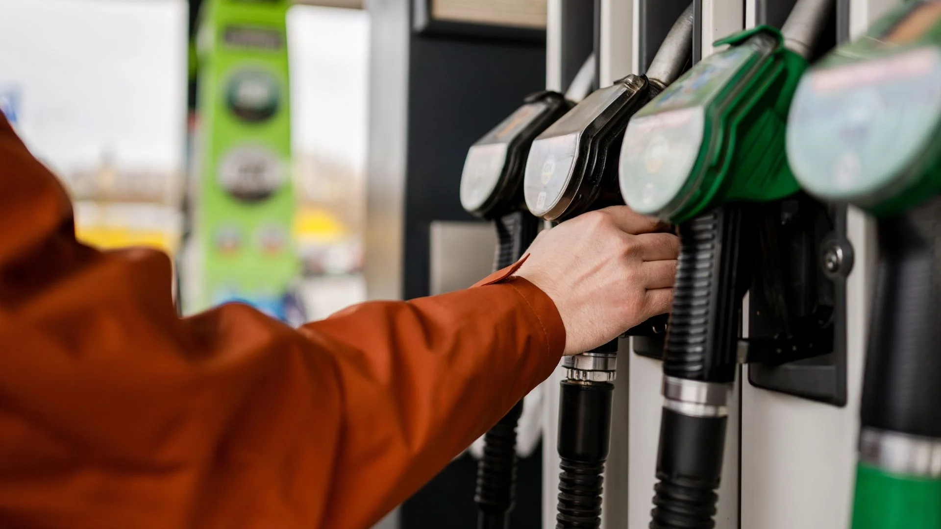 Idą kolejne podwyżki na stacjach. Benzyna po 8 zł, a diesel przebije 9?/ Człowiek sięga po pompę paliwa przy dystrybutorze na stacji.