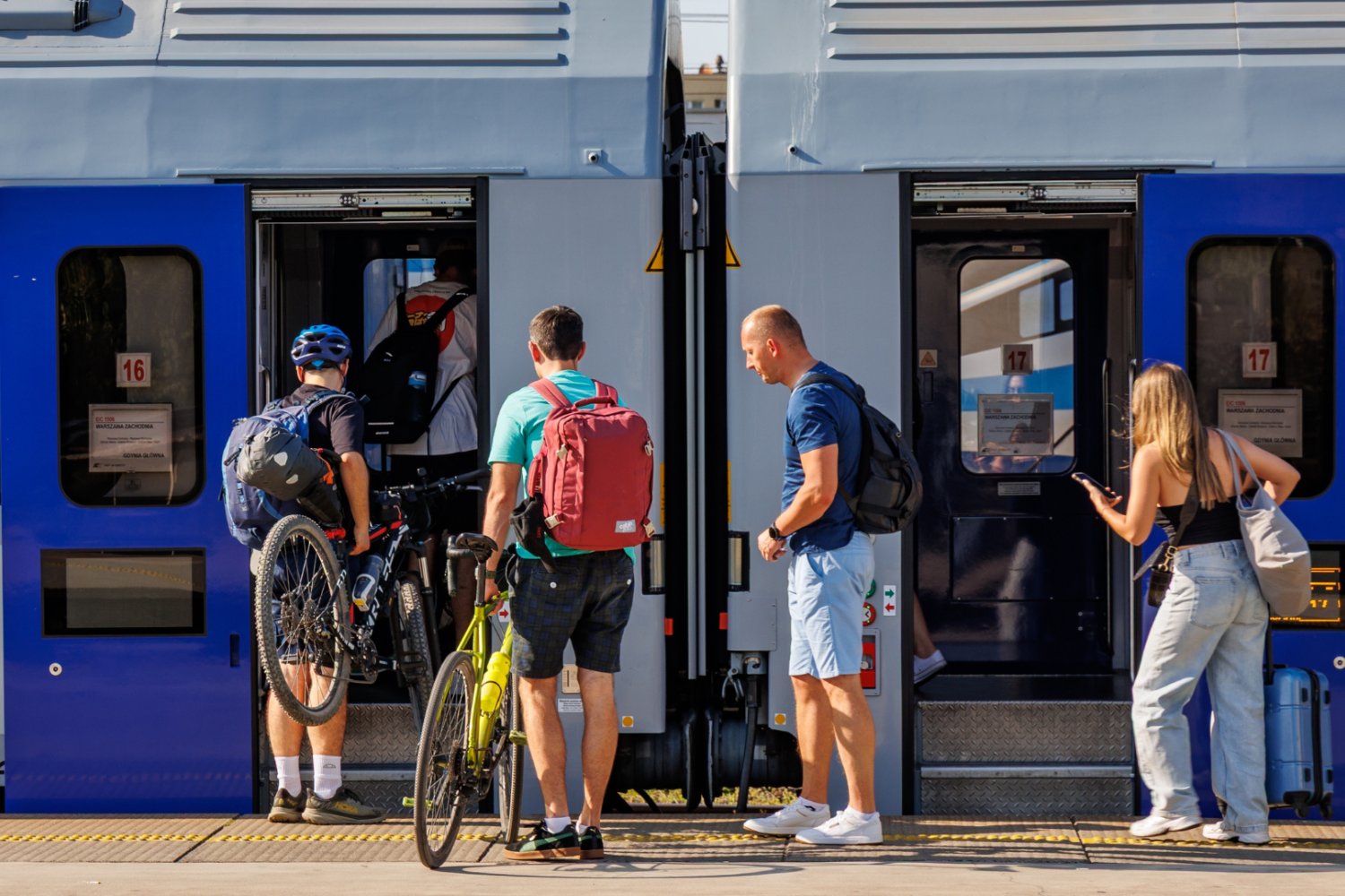 Pociąg PKP Intercity i pasażerowie, którzy wnoszą rowery na pokład.