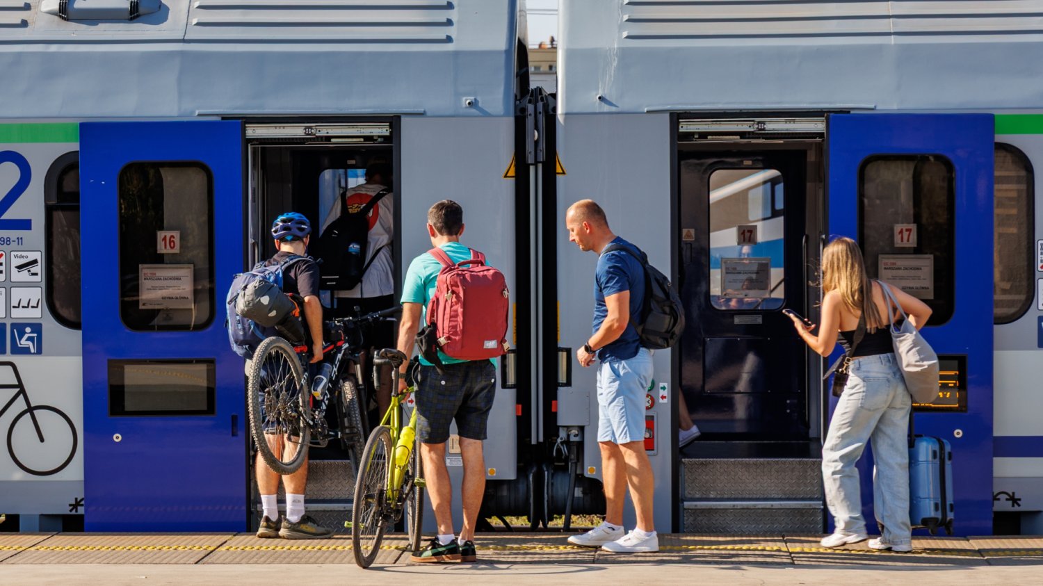 Pociąg PKP Intercity i pasażerowie, którzy wnoszą rowery na pokład.