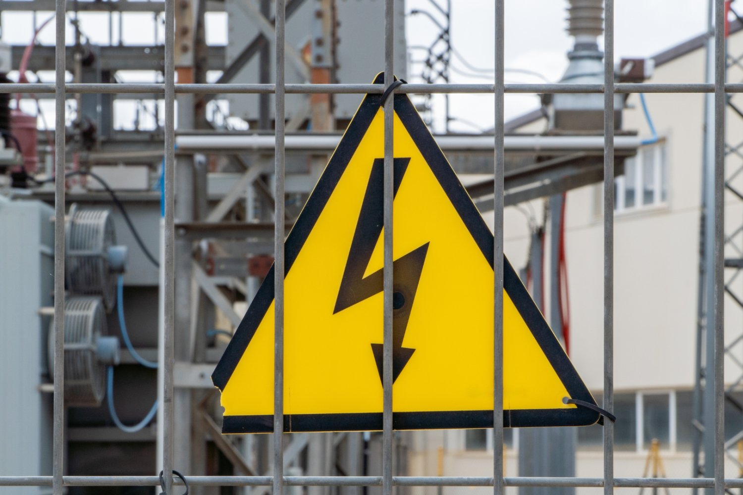 Wieczorem cena prądu wystrzeli powyżej 2 tys. zł za MWh. Wiemy, co do tego doprowadziło Znak ostrzegawczy o wysokim napieciu. W tle elektrownia.